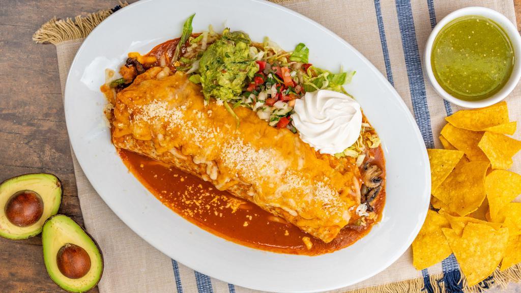 Fajita Burrito · Flour tortilla filled with your choice of chicken or steak, covered with enchilada sauce and cotija cheese, garnished with lettuce, pico de gallo, sour cream and guacamole, and served with rice and beans.