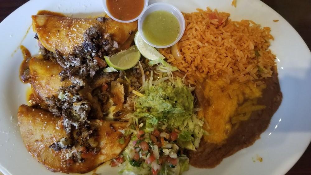 Tacos Al Carbon · 3 corn tortillas dipped in a red sauce with steak or chicken then topped with pico de gallo and Mexican cheese. Served with guacamole. Served with Spanish rice and refried beans.