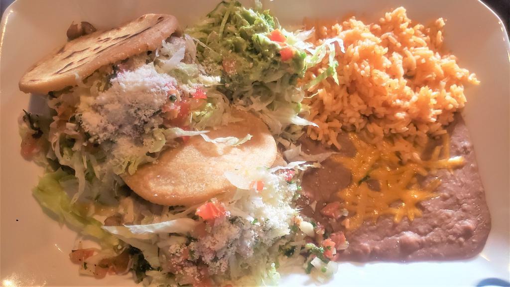 Gorditas · Two small gorditas from corn, stuffed with meat, served with beans and rice then garnished with sour cream, guacamole, lettuce, cotija cheese, and pico de gallo.