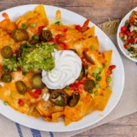 Super Nachos · Tortilla chips topped with melted cheese, tomatoes, green onions, jalapeños, sour cream, and...
