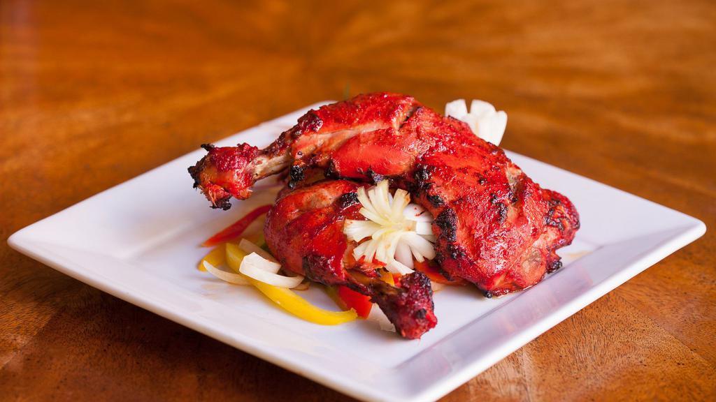 Tandoori Chicken · Gluten-free. Chicken marinated in thick yogurt, spices and kashmiri cayenne, served with onions, peppers and lemon wedges.