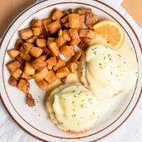 Classic Eggs Benedict · Two poached eggs and Canadian bacon atop English muffin halves. Topped with hollandaise sauc...