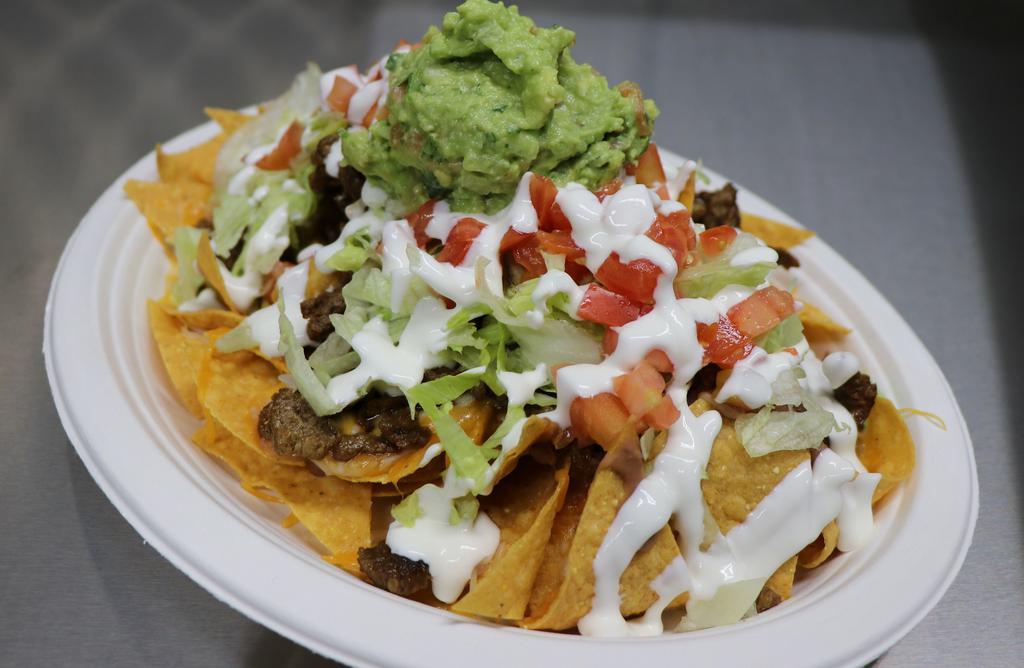 Nachos · Mix of Jack and Cheddar cheese melted with beans, choice of meat, lettuce, tomato, sour cream and guacamole. Choice of house-made chips or french fries!