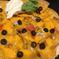 Nachos · Tortilla chips topped with cheese, beans, onions, tomatoes, olives, sour cream and fresh gua...