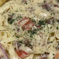 Fettuccini Carbonara · Fettuccini pasta tossed with prosciutto, mushrooms, onions and diced tomatoes in creamy Parm...