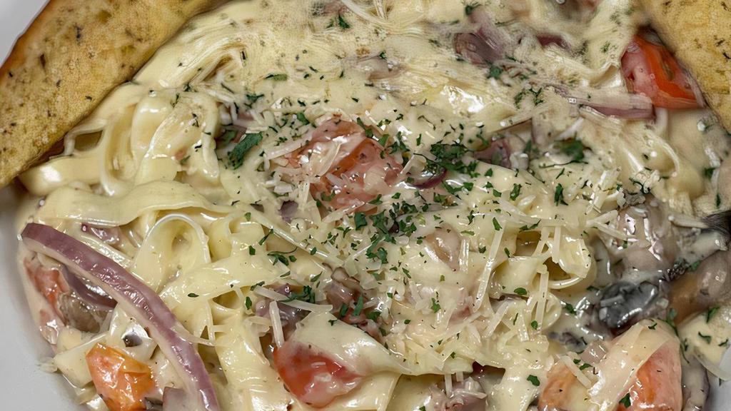 Fettuccini Carbonara · Fettuccini pasta tossed with prosciutto, mushrooms, onions and diced tomatoes in creamy Parmesan cheese sauce.