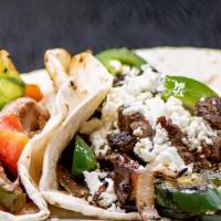 Taco Norteño · Our famous taco norteno served in a Flour tortilla with teak, grilled onions,  topped with m...