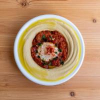 Hummus Shakshuka · A poached egg basking in a hearty tomato pepper stew.