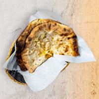 Fire Naan · Leavened flatbread made from white flour, cooked until puffy and blistering, then coated in ...