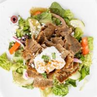 Gyro Salad · Gyro slices on a bed of Greek salad drizzled with tzatziki sauce and feta cheese. Kalamata o...