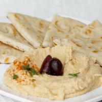 Hummus · Garbanzos blended with garlic and lemon tahini served with pita bread.