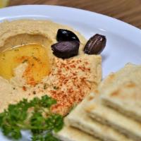 Hummus · Garbanzos blended with garlic and lemon tahini served with pita bread.