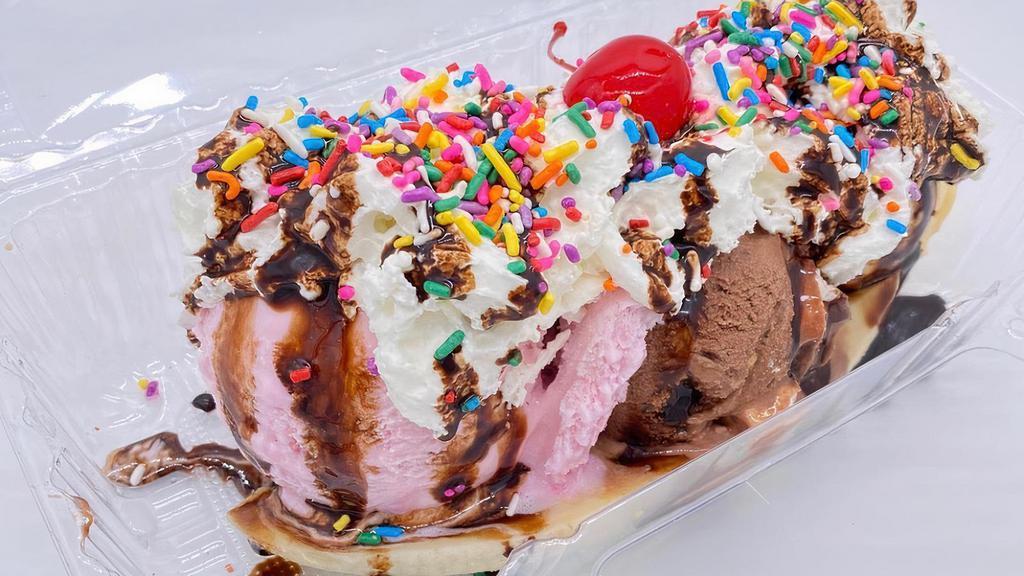 Banana Split · Banana topped with ice cream (two scoops), whip cream, sprinkles, a cherry, and chocolate syrup.