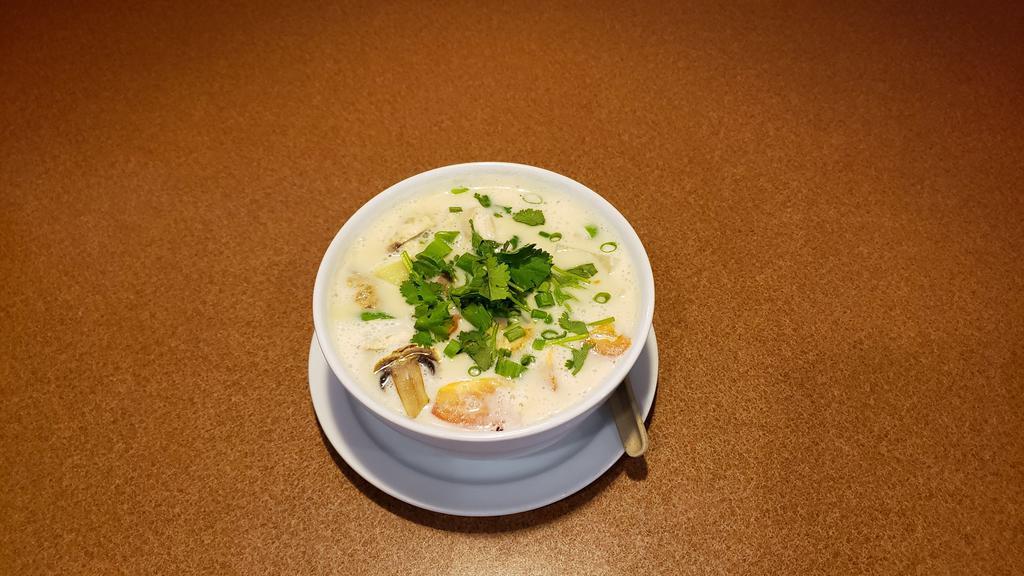 Tom Kha (Small) · Hot and sour creamy Thai coconut milk soup with a touch of lime juice, lemongrass, galangal root, tomatoes, mushroom, onions, and topped with green onions, cilantro.