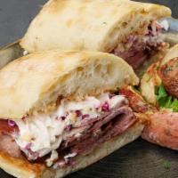 Brisket Sandwich · Slow hickory smoked beef brisket served on a grilled ciabatta roll with honey lime slaw, pic...