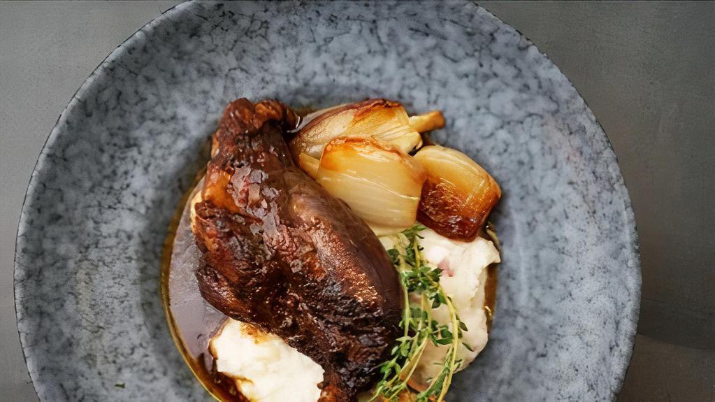 Stewed Lamb Shank · Slow-braised tender lamb shank with shallot confit, roasted garlic mashed red potatoes and mint-infused demi-glace sauce.