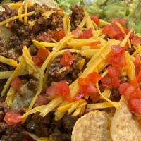 Nachos Revolution · Seasoned beef, shredded cheddar, tomato, sour cream, guacamole and nacho cheese.