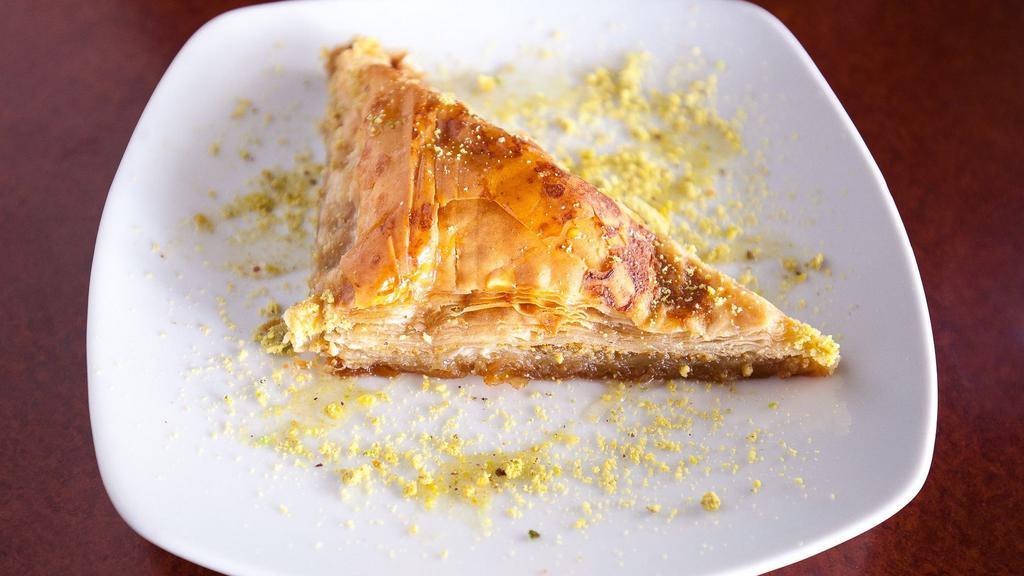 Baklava · Vegan. Cardamom rose water syrup and roasted pistachios layered in golden flaky layers of phyllo dough.