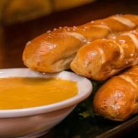 Garlic Butter Pretzel Stix · Three of oven baked soft pretzels served with forum made beer cheese sauce and mustard aioli.