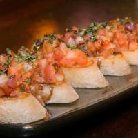 T-Town Bruschetta · Grilled sourdough topped with tomatoes, onions, and fresh basil. Drizzled with a sweet balsa...