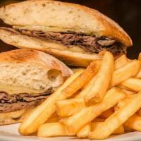 Pardon Our French Dip · Roast beef simmered in au jus then piled high on grilled garlic buttered baguette with melte...