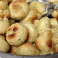 Garlic Knots · Knot shaped pizza dough baked and tossed in olive oil, Parmesan cheese served with side of h...