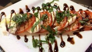 Caprese Salad · Thick sliced tomato topped with fresh mozzarella cheese, basil and drizzled with extra virgin olive oil and balsamic glaze.