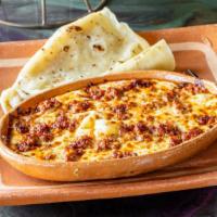 Queso Fundido · Oaxacan cheese and goat cheese flameado. Choose one item of roasted red pepper, poblano, mus...