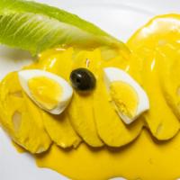 Papa A La Huancaina · Potato topped with a savory cheese and yellow aji sauce served with hard boiled egg.