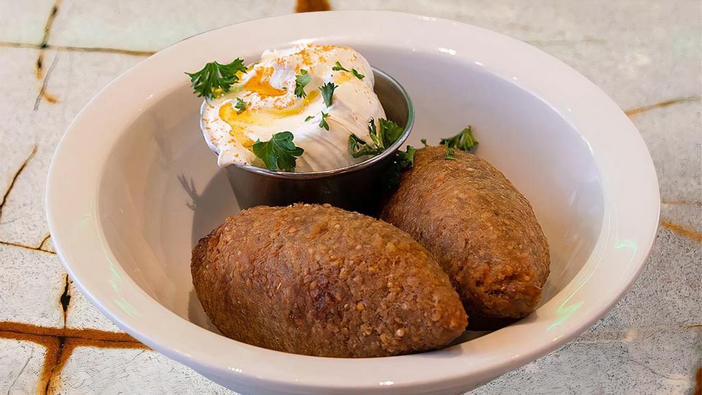 Beef Kibbee Balls · Wheat bulgur stuffed with seasoned ground beef and sautéed onions rolled up into a ball and fried to perfection. Served with homemade tzatziki sauce.