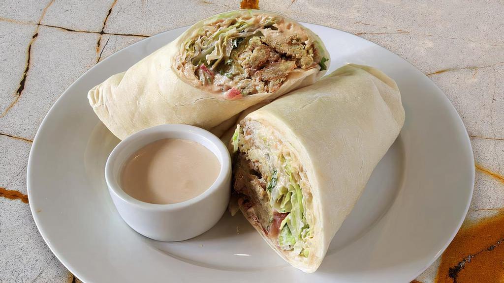 Falafel Wrap · Original hummus, our exclusive falafel made from scratch, served on our house pita bread, topped with lettuce, tomatoes, parsley, and garlic tahini sauce. Vegan. Vegetarian.