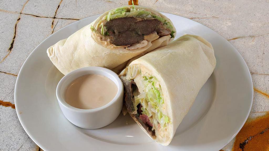 Kafta Sandwich · Original hummus, charbroiled seasoned beef mixed with parsley and onions, served on our house pita bread and topped with lettuce, tomatoes, parsley, and our garlic tahini sauce.