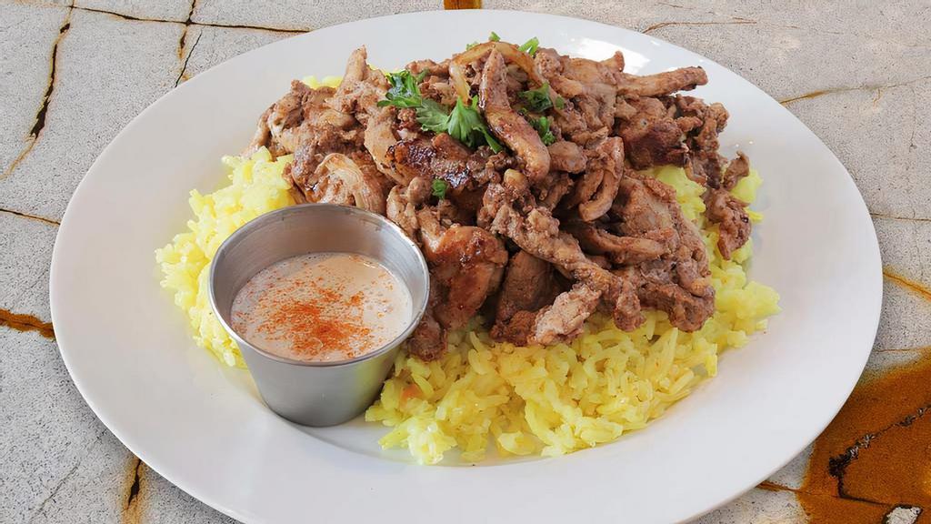 Lamb Shawarma Platter · In house sliced meat marinated with sautéed onions served over seasoned basmati rice and a side of homemade tahini sauce.