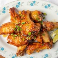Chili-Garlic Chicken Wings · Chicken wings slow-roasted then fried crispy, tossed with chili, garlic, fish sauce, lime ju...