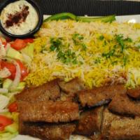 Lamb Gyro Over Rice · Slices with rice, salad and tzatziki sauce.