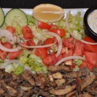 Chicken Shawarma Over Salad · Slices with salad and tahini sauce.