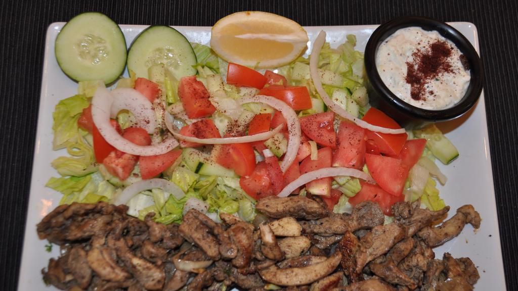 Chicken Shawarma Over Salad · Slices with salad and tahini sauce.