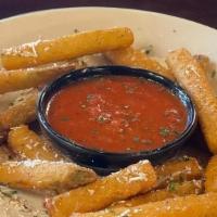Fried Zucchini · Breaded zucchini sticks fried golden brown and topped with our famous Mizithra cheese.  Serv...
