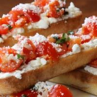 Goat Cheese Bruschetta · Thick cut toasted French baguette slices with goat cheese, tomato + fresh basil, drizzled wi...