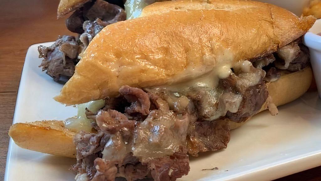 Prime Rib French Dip · Thin sliced prime rib with caramelized onions, white cheddar and creamy horseradish sour cream on butter-toasted baguette. Served with natural au jus for dipping
