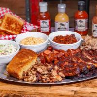 Family Sampler (Feeds 4-6) · Full slab of ribs, 1/2lb Smoked chicken, 1/2lb hot links, & 1/2lb pulled pork. Served with c...