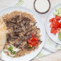 Beef Shawarma · Roasted thin slices of marinated beef served with rice, salad, Iraqi bread and pickles.
