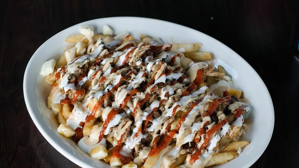 Shawarma Fries · Doner style lamb on a bed of curly fries. It also comes dripping with garlic & hot sauce.