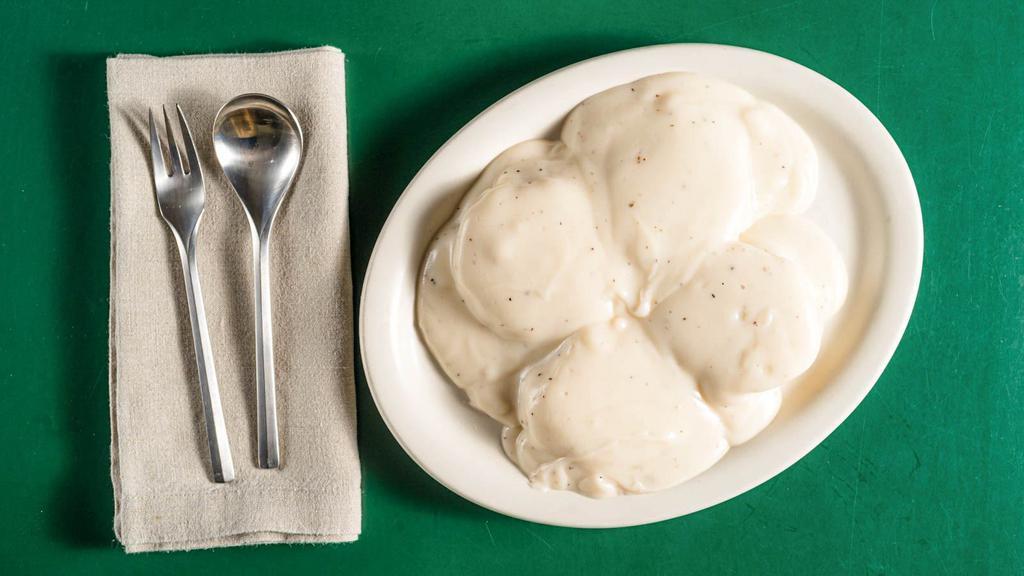 Biscuits And Gravy · Two buttermilk biscuits halved and smothered in country gravy.
