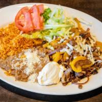 Fajitas · Grilled steak or chicken with sautéed peppers and onions, served with sour cream and guacamo...