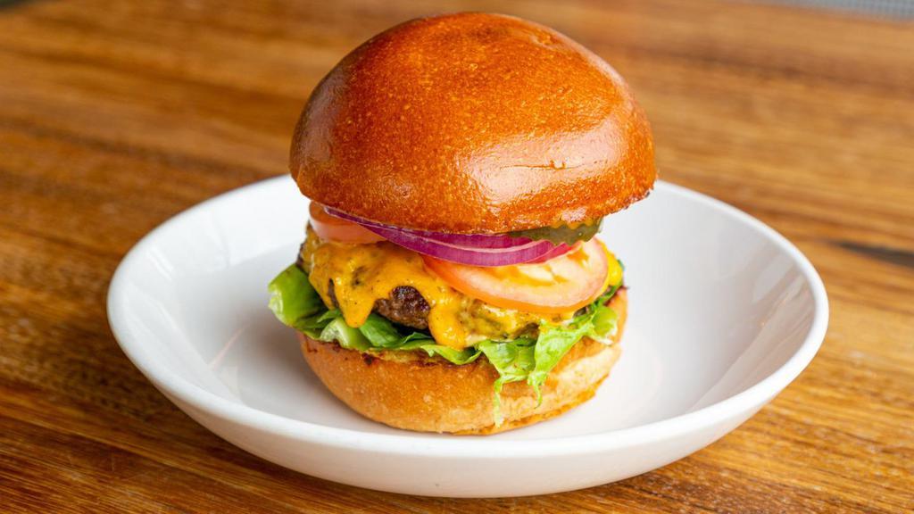 Bevvy Burger · Beef patty, american cheese, tomato, arugula, onions, pickles, red relish, and buttermilk bun.