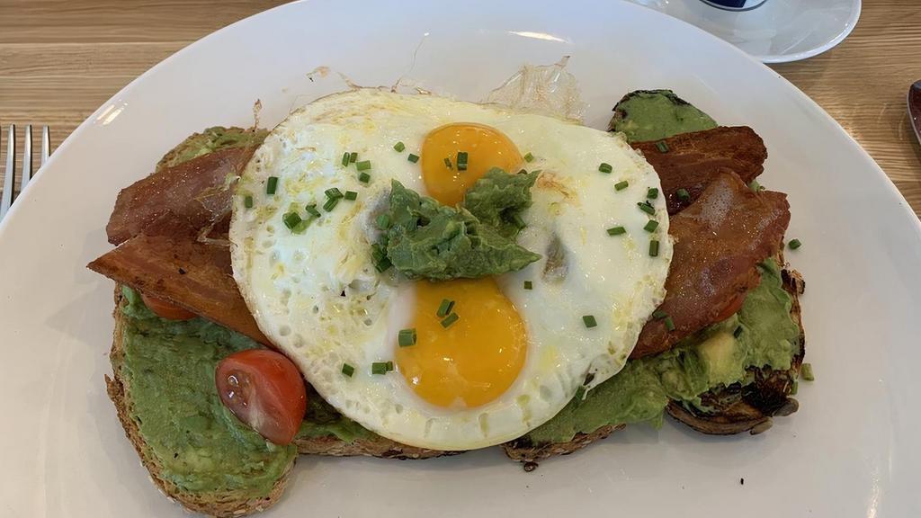 Avocado Toast · Grilled 7 grain bread, smashed avocado, Applewood smoked bacon, cherry tomatoes, 2 eggs, & chives.