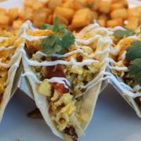Juan'S Breakfast Tacos · Three corn tortillas filled with scrambled eggs, hash browns, jack cheese, topped with sour ...