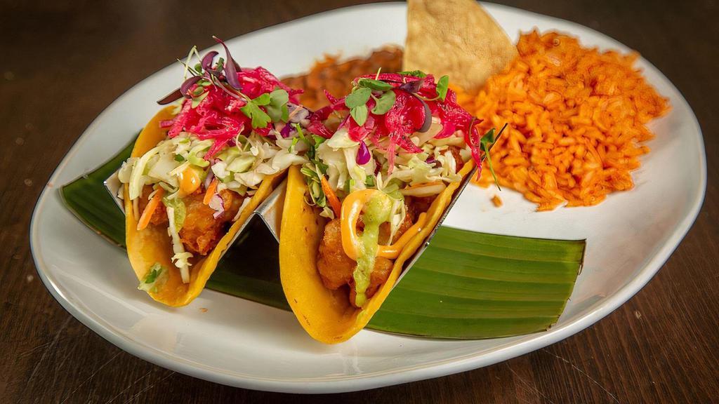 3 Baja Shrimp Tacos · Beer Battered Shrimp, Corn Tortillas, Tomatillo-Avocado Sauce, Chipotle Aioli, Cabbage Mix, Pickled Red Onions, Micro Greens, Rice, Refried Beans