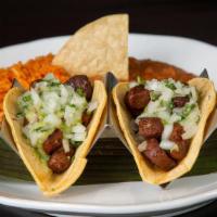 3 Vegan Beef Tacos · Vegan Beef, Corn Tortillas, Tomatillo-Avocado Sauce, Onions, Cilantro, Rice, Refried Beans